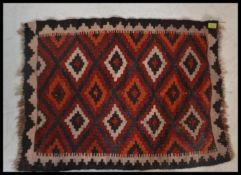 A 20th century  Islamic / Persian rug of small form with geometric patterns and triangular