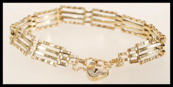 A hallmarked 9ct gold heart lock bracelet with a safety chain. Hallmarked London. Total weight 6.