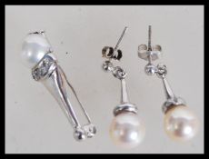A hallmarked 18ct white gold brooch set with a pearl and white stones, with a pair of matching