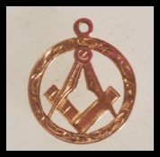 A hallmarked 9ct gold masonic pendant of circular form with central masonic symbol and engraved