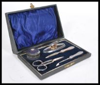 A silver hallmarked cased ladies vanity set comprising scissors, button hook, rouge pot, powder puff