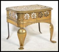 A 19th century George III brass footman being raised on cabriole style legs with pierced frieze