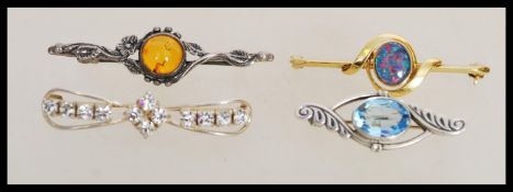 A group of four sterling silver and silver gilt bar brooches to include silver gilt brooch with opal