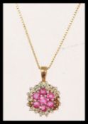 A hallmarked 9ct gold ruby and diamond cluster pendant necklace. Chain measures 18 inches, pendant