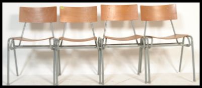 A set of four vintage retro 20th Century ply stacking school chairs raised on tubular supports.