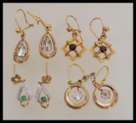A group of 9ct gold earrings to include square white stone ring drops, green and white stone