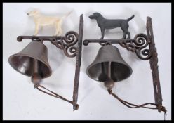 Two 20th century hand painted exterior cast iron metal wall hanging bells. Each with a hand