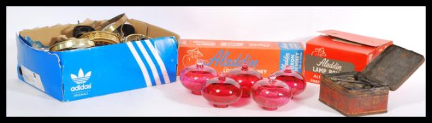 A selection of early 20th Century oil lamp parts to include a selection of cranberry glass