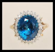 A hallmarked 9ct gold topaz and diamond dress ring having a large central oval mixed cut topaz
