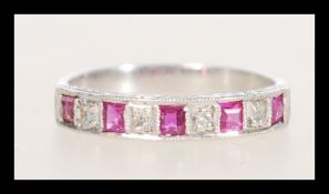 A stamped 18ct white gold ring channel set with square rubies and diamonds. Weight 2.6g. Size L.
