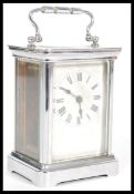 A 20th Century carriage clock in a silver white metal case having a white enamelled face to the