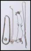 A selection of silver necklaces to include a heart pendant necklace having pierced decoration, a