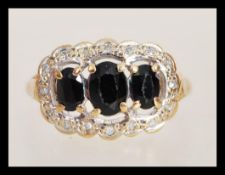 A hallmarked 9ct three stone sapphire ring having three faceted sapphires in prong settings with a