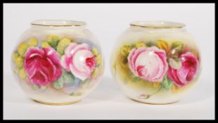 A pair of Royal Worcestepainted Spill Vases of wrythen fluted compressed spherical form, decorated