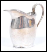 A hallmarked silver early 20th century creamer jug having a shaped acanthus leaf and reeded handle