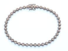 A hallmarked 18ct white gold and diamond tennis line bracelet. The bracelet being set with 41
