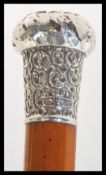 A wooden walking stick cane having a silver hallma