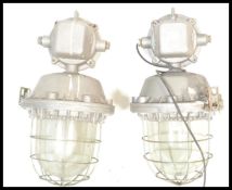 A pair of retro 20th Century large industrial factory bulk cage lights, having a cast iron body,