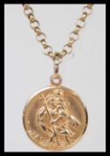 A hallmarked 9ct gold St Christopher pendant on a hallmarked 9ct gold figaro chain link necklace.