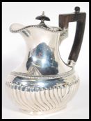 An early 20th Century Victorian hallmarked silver hot water jug by James Dixon and Sons Sheffield.