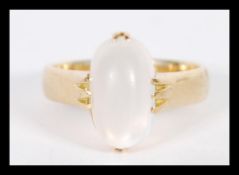 An hallmarked 18ct gold ring with a white polished cabochon stone set within a prong setting. Size