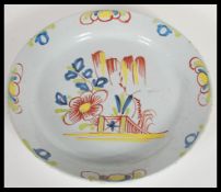 An 18th Century English Delft pottery charger plate of circular form having hand polychrome