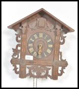 An early 20th Century Black Forest type wooden cuckoo clock having acorn weights with scrolled
