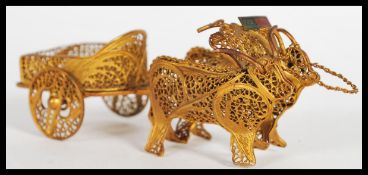 A 20th Century Portuguese gilt silver filigree gondola being pulled by two bulls. The cart having