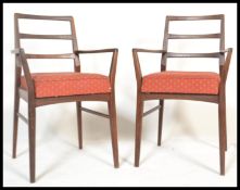 A pair of retro teak wood Danish inspired carver dining chairs, the open framed ladder back chairs