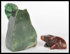 An early 20th Century carved brown jade figurine netsuke in the form of an ox with marks to base