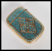 A brass and enamel vesta match case in the Anderson style having hinged lid and scrolled