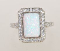 A sterling silver Art Deco style ring having a central opal panel and decorated with CZ stones.