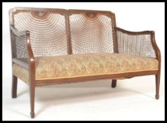 A Georgian revival mahogany framed bergere two seat sofa, fan back weave to the back and sides