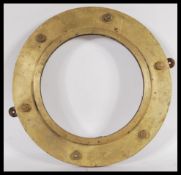 A vintage early 20th Century bronze ships porthole, the porthole mounted to wood with hanging