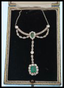 An early 20th Century Edwardian diamond and emerald necklace having a drop pendant design, the