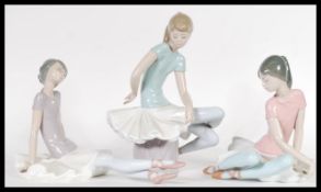 A collection of three 20th Century Lladro ceramic figurines of young ballerina girls in relaxed