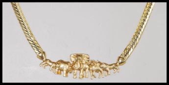 A 9ct gold necklace having a flat link chain with a attached to a pendant in the form of African