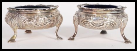 A near matching pair of Georgian and Victorian table salts salt cellars raised on shell cabriole
