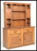 A 19th Century Victorian oak kitchen dresser having a wide base comprising a series of drawers and