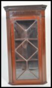 An early 20th Century Edwardian mahogany corner cabinet having carved details with boxwood inlay.