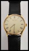A Longines watch having a gilt dial with Roman numeral chapter ring and faceted hands on a black