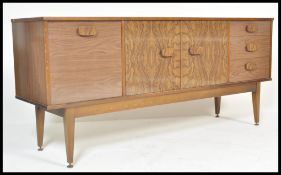 A vintage retro 20th Century veneered sideboard credenza raised on shaped tapering square supports
