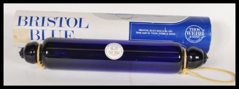 A 20th Century Bristol Blue glass rolling pin, by Thomas Webb with moulded ends, within its original