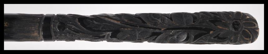 An early 20th Century Edwardian silk parasol with an ebonised carved handle the silk with