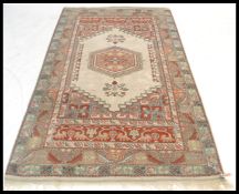 A 20th Century Persian Islamic rug having a red gr