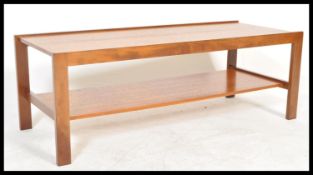 A retro 20th Century teak wood coffee table, rectangular top raise on square supports united by
