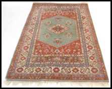 A 20th Century Persian Islamic rug having a red gr