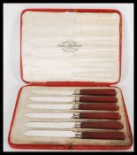 An early 20th Century set of six hallmarked silver collared dessert knives having red bakelite