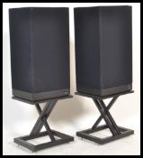 A pair of retro KEF speakers in black finish on ebonised floor stands.