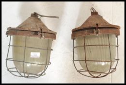 A pair of vintage / retro  20th Century industrial factory bulkhead cage lights, having a cast body,
